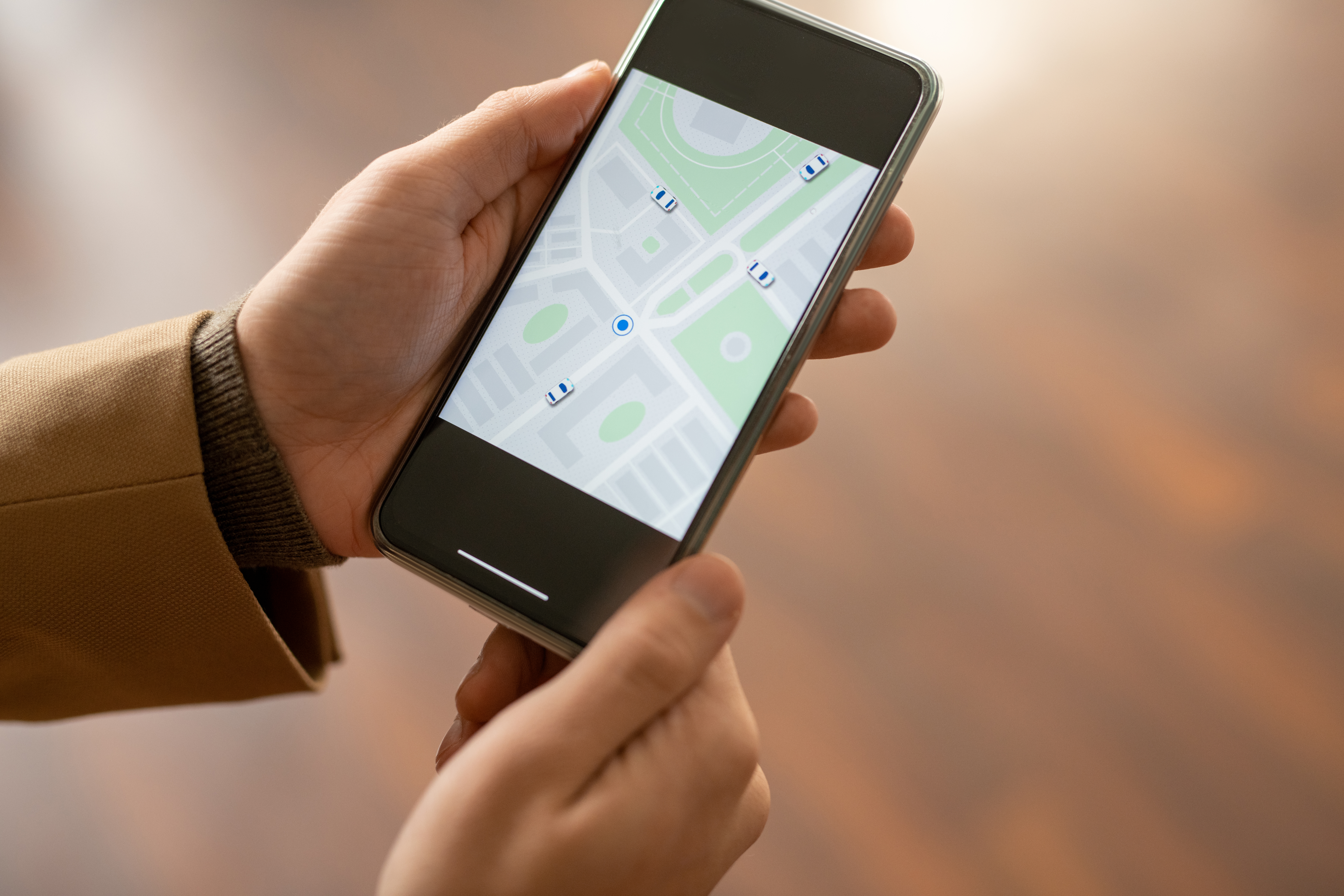 Hands of contemporary young elegant businessman using map in smartphone