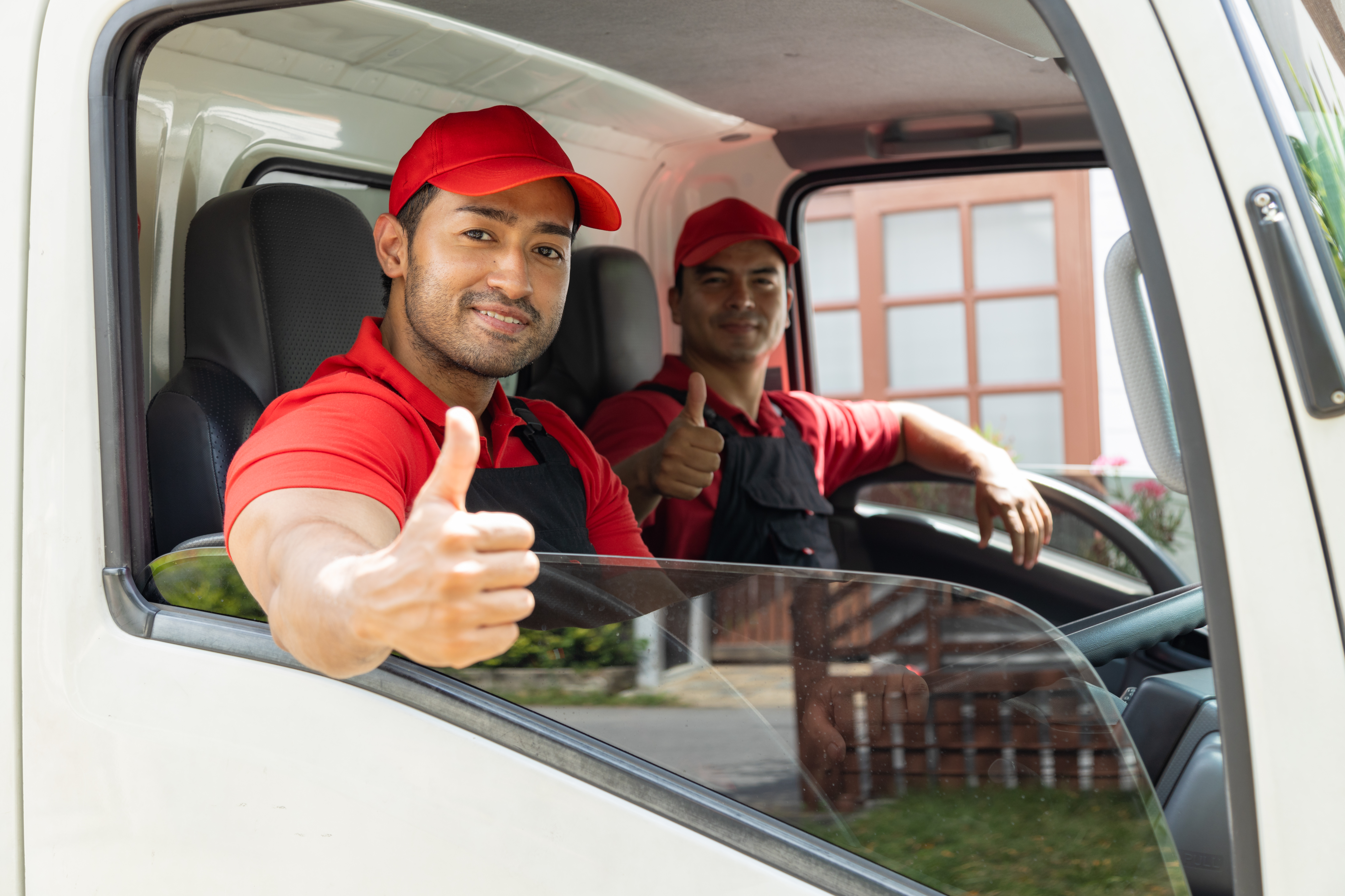 Portrait of two movers unloading boxes and furniture from a pick