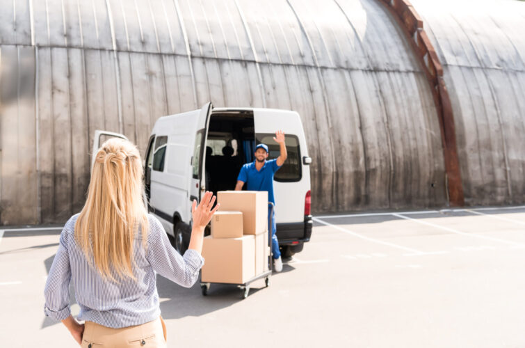 handsome young courier delivering packages for woman